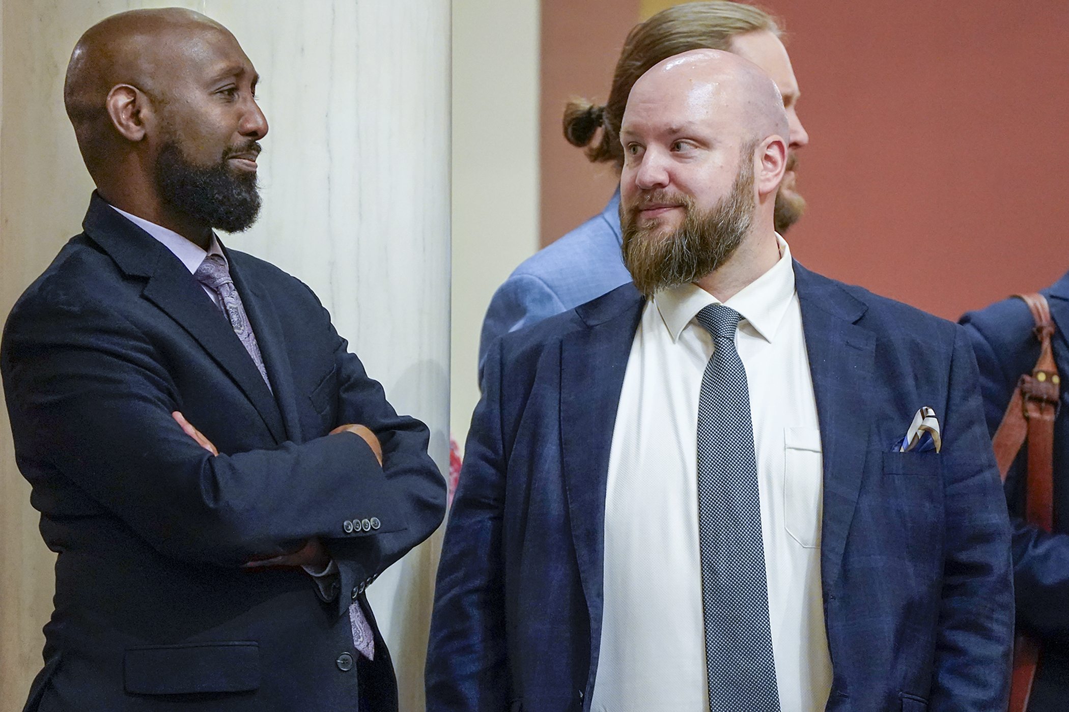 Rep. Mohamud Noor and Rep. Joe Schomacker, co-chairs of the House Human Services Finance and Policy Committee, chat on the House Floor following passage of the omnibus human services policy bill. It now returns to the Senate for concurrence. (Photo by Michele Jokinen)